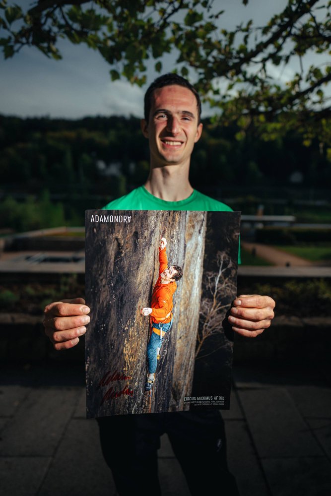 Adam Ondra posing with his Red Nails poster from Saxony