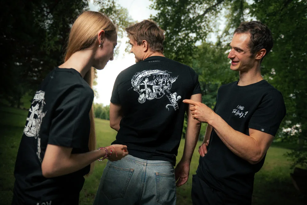 Adam Ondra pointing on back side of the AO "I hate toehooks" black T-shirt