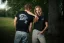 A man and a woman posing in the Adam Ondra "I hate toehooks" black T-shirt, front and back side