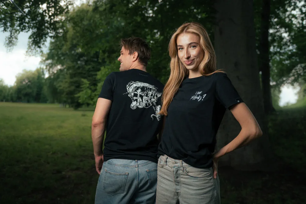 A man and a woman posing in the Adam Ondra "I hate toehooks" black T-shirt, front and back side