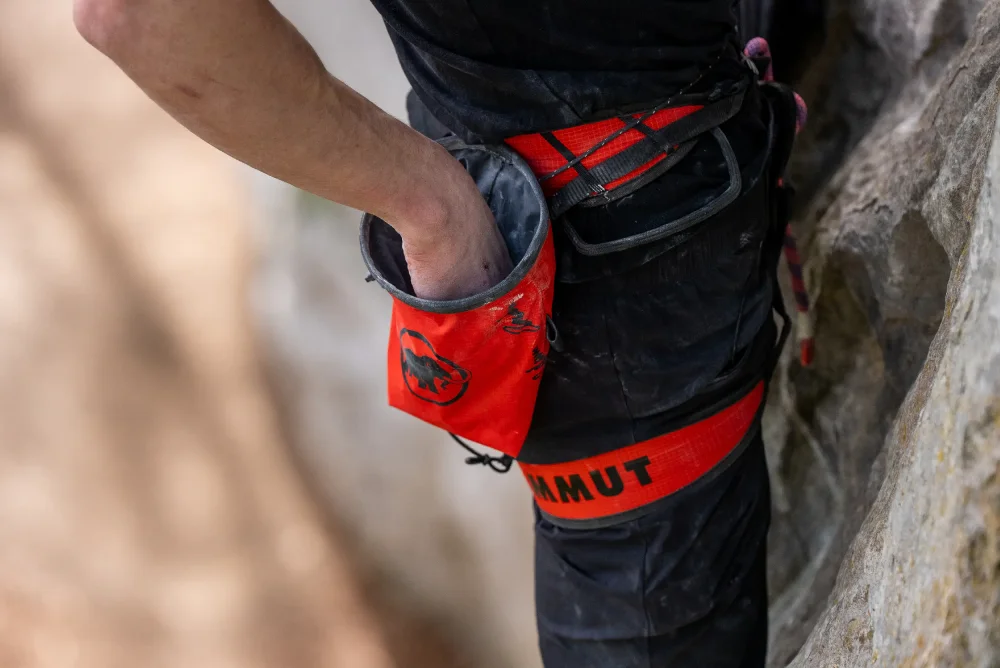 Adam Ondra chalking up while climbing with his Mammut Sender Light Chalk Bag