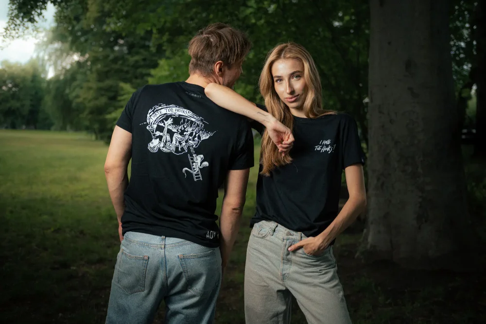 A man and a woman posing in the Adam Ondra "I hate toehooks" black T-shirt, front and back side