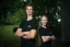 Adam Ondra and a woman model posing in the AO "I hate toehooks" black T-shirt, front side