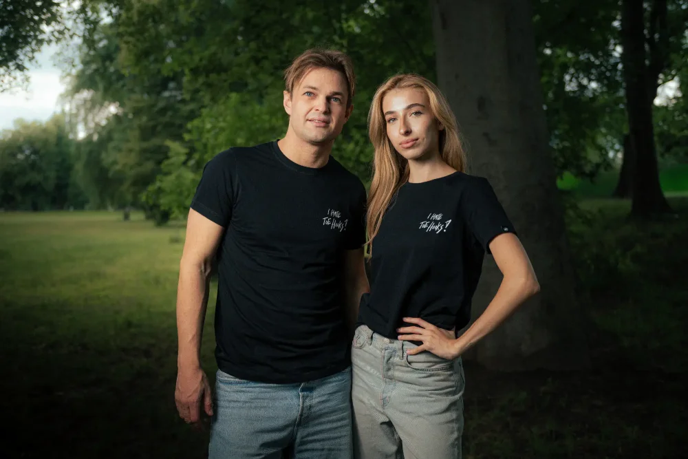 A man and a woman posing in the Adam Ondra "I hate toehooks" black T-shirt, front side